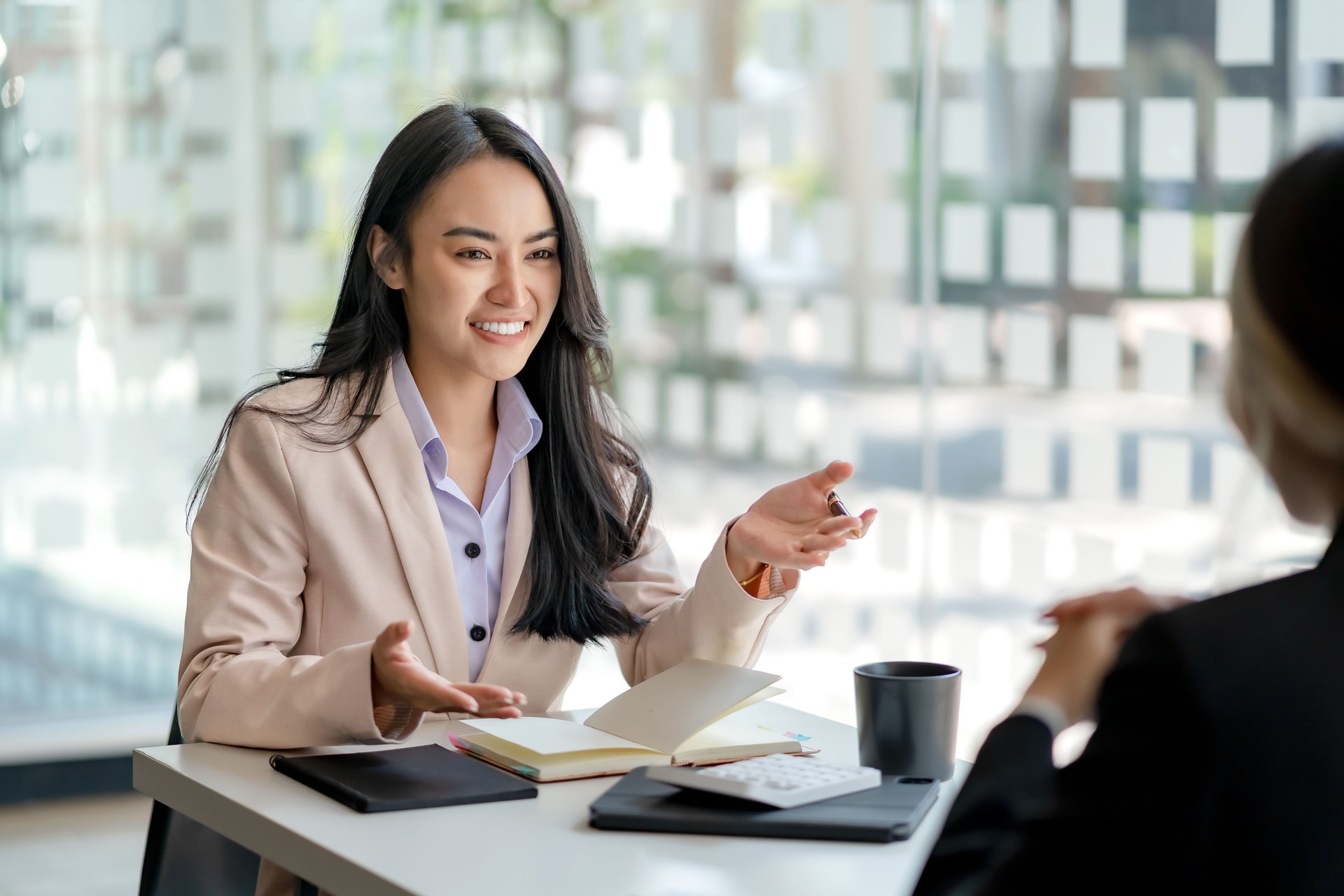 Two young Asian business woman talk, consult, discuss working with new startup project idea presentation analyze plan marketing and investment in the office.